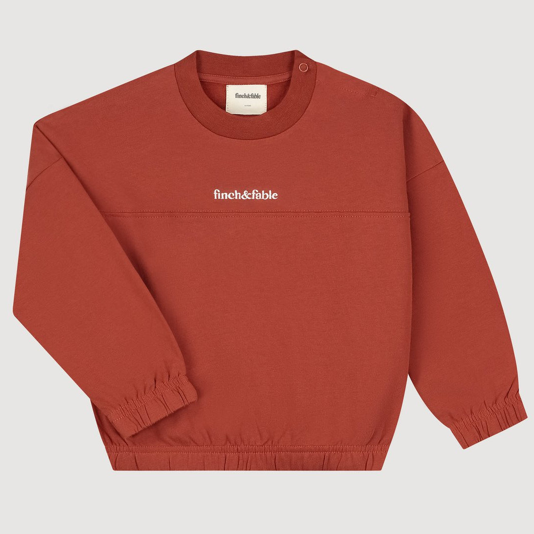 Detail van het geborduurde Finch & Fable logo op het sweatshirt