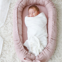 Linnen babynest met strik – Comfortabel en veilig voor pasgeborenen.