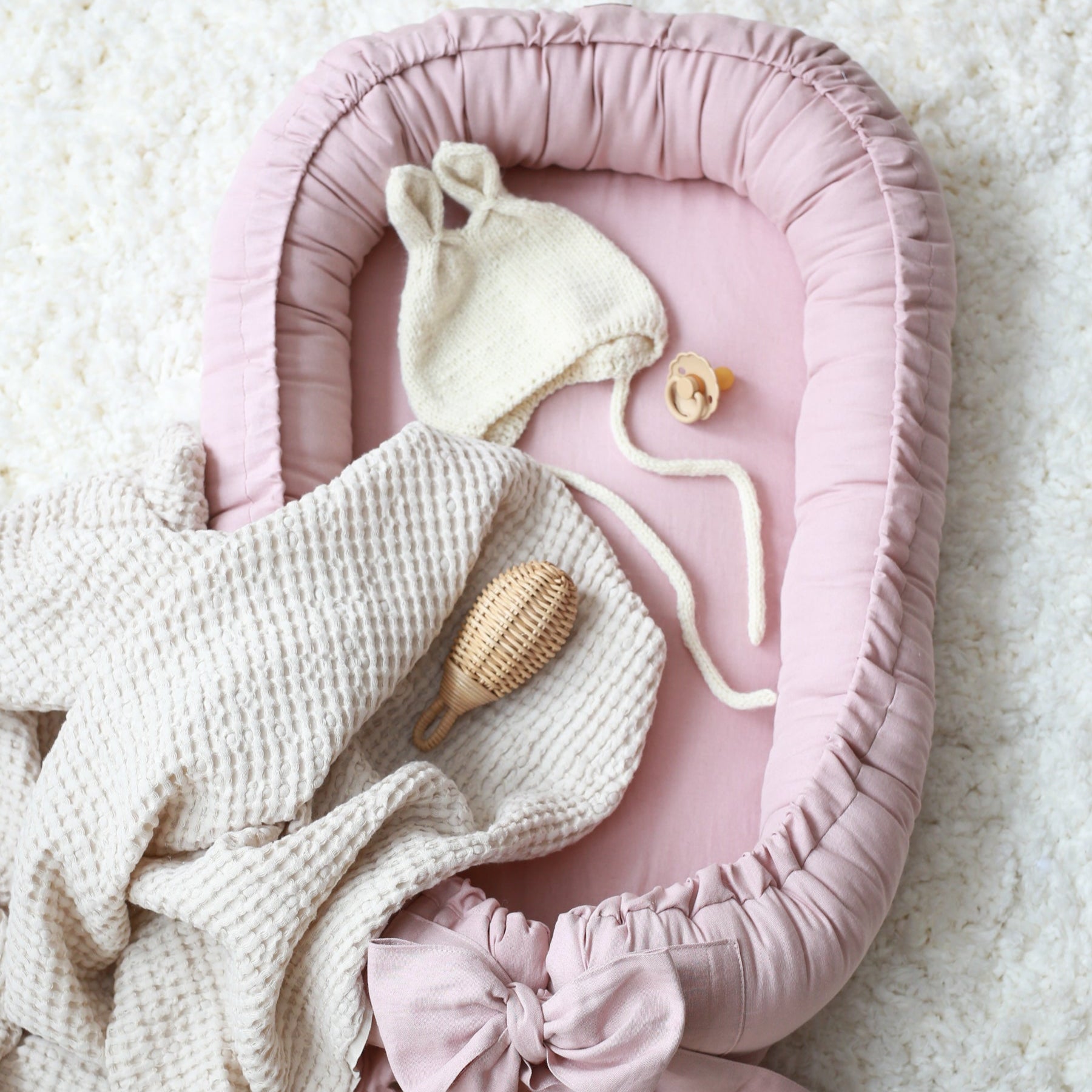 Linnen babynest met strik – Comfortabel en veilig voor pasgeborenen.