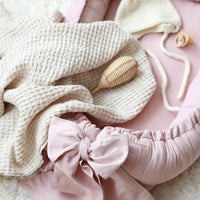 Linnen babynest met strik – Comfortabel en veilig voor pasgeborenen.